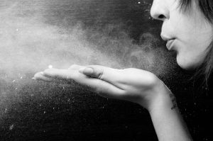 photo of woman blowing dust from her hand